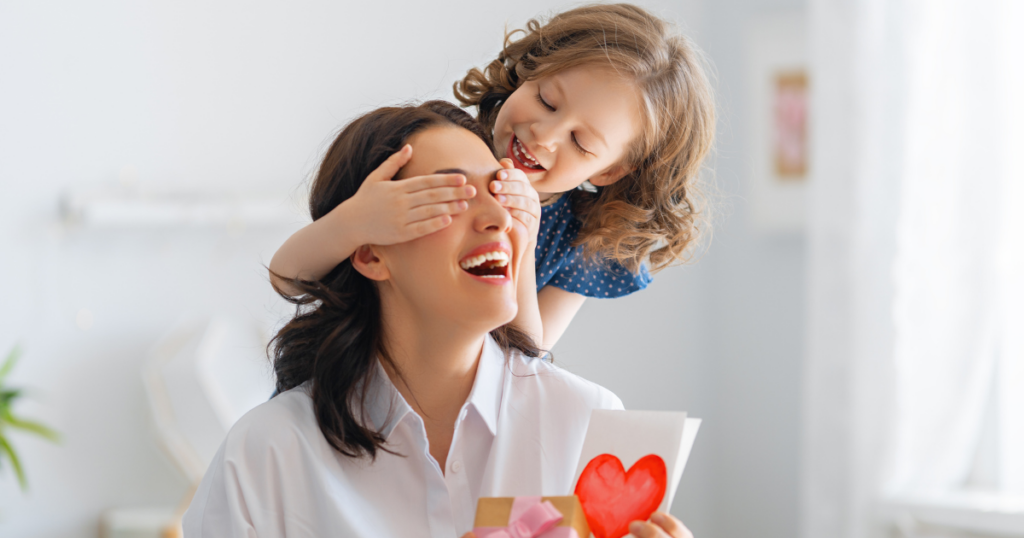 Mother and child celebrating Mother’s Day with a handmade card, promoting Mother’s Day brunch at Hash House A Go Go Orlando with limited-time menu favorites.